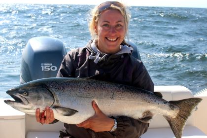 A happy guest with a Chinook Salmon aboard the 'Red Sky'